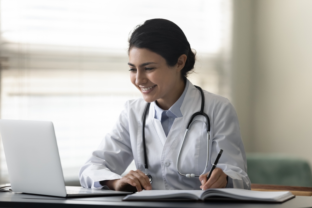 Smiling,Indian,Female,Doctor,Physician,In,Uniform,With,Stethoscope,Using